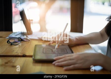 Primo piano dello sviluppatore ux femminile e del progettista ui sull'interfaccia dell'app per telefono cellulare nel salotto di casa.concetto di agenzia di sviluppo digitale creativo. Foto Stock
