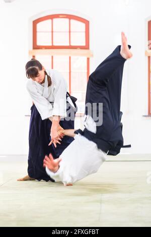 L uomo e la donna di combattere ad Aikido la formazione nella scuola di arti marziali Foto Stock
