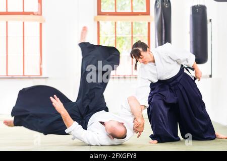 L uomo e la donna di combattere ad Aikido la formazione nella scuola di arti marziali Foto Stock
