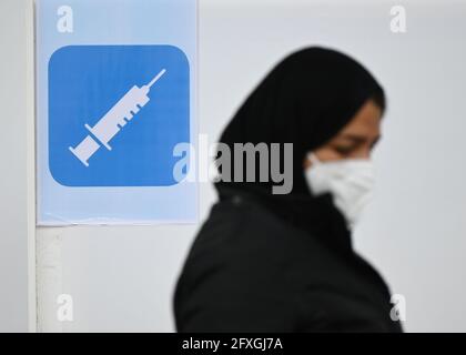 27 maggio 2021, Hessen, Francoforte sul meno: Una donna entra in uno stand di vaccinazione nel centro culturale della moschea Imam Sajad, fondata dagli afgani della zona del Reno-meno nel quartiere di Fechenheim. Per tre giorni consecutivi, quasi 200 persone vengono vaccinate ogni giorno presso il centro culturale da un team mobile di vaccinazione di Malteser Hilfsdienst. La campagna di vaccinazione nella moschea fa parte delle strategie della città di Francoforte per un tasso elevato di vaccinazione. Foto: Arne Dedert/dpa/PISCINA/dpa Foto Stock