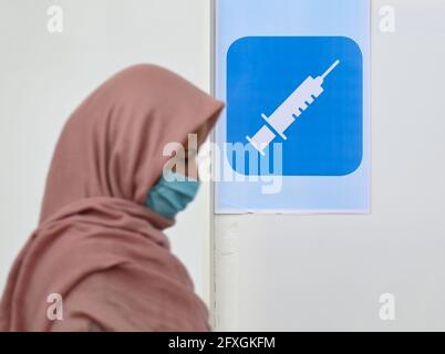 27 maggio 2021, Hessen, Francoforte sul meno: Una donna entra in uno stand di vaccinazione nel centro culturale della moschea Imam Sajad, fondata dagli afgani della zona del Reno-meno nel quartiere di Fechenheim. Per tre giorni consecutivi, quasi 200 persone vengono vaccinate ogni giorno presso il centro culturale da un team mobile di vaccinazione di Malteser Hilfsdienst. La campagna di vaccinazione nella moschea fa parte delle strategie della città di Francoforte per un tasso elevato di vaccinazione. Foto: Arne Dedert/dpa/PISCINA/dpa Foto Stock