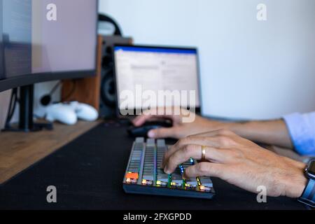 Le mani dell'uomo che digitano su una tastiera Foto Stock