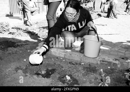 JOHANNESBURG, SUD AFRICA - 05 gennaio 2021: Soweto, Sud Africa - 21 luglio 2012: Persone diverse che eseguono il giardinaggio di servizio della Comunità a Townsh locale Foto Stock