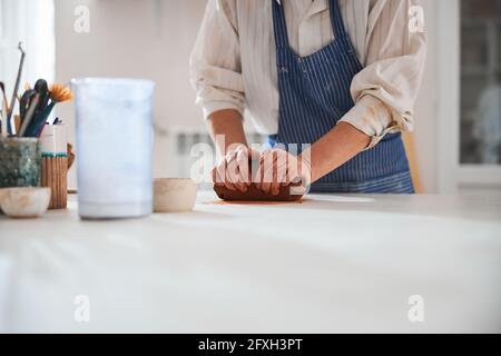 Vasaio competente che prepara creta per fare le stoviglie Foto Stock