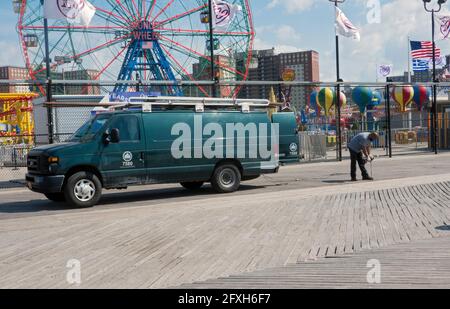 Un operaio del reparto Parchi di New York City regola e fissa le spranghe sulla passerella a Coney Island, Brooklyn, New York City. Foto Stock