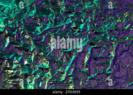Struttura cromata con effetto struttura sminuzzata. Verde e violetto di moda futuristico sfondo con. Sfondo colorato con rughe cromate metallizzate Foto Stock
