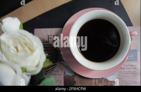 caffè nero e caffè di piselli su giornale. Foto Stock