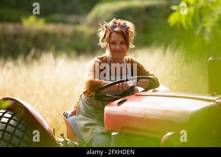 Ritratto felice agricoltore che guida il trattore Foto Stock