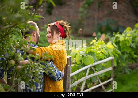 Felice coppia abbracciando e parlando in giardino Foto Stock
