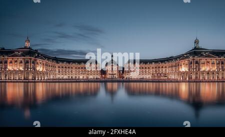 FRANCIA. GIRONDE (33), BORDEAUX, LA PLACE DE LA BOURSE CON LO SPECCHIO D'ACQUA IN LUNGA ESPOSIZIONE ALL'ORA BLU (ARCHITETTI SPECCHIO D'ACQUA, MICHEL CORAJO Foto Stock