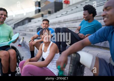 Felice giovane atleta amici in bleachers Foto Stock