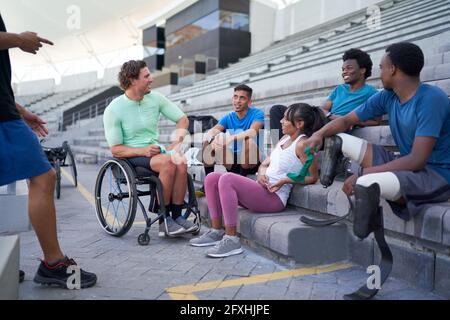 Diversi giovani atleti che parlano nei bleachers dello stadio Foto Stock