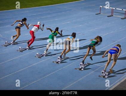 Atlete da campo e da pista a blocchi di partenza Foto Stock