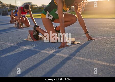 Atlete da campo e da pista pronte ai blocchi di partenza in pista Foto Stock