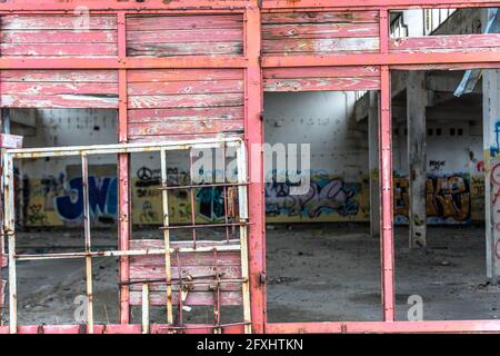 Industria abbandonata, vecchio muro industriale con porta danneggiata Foto Stock