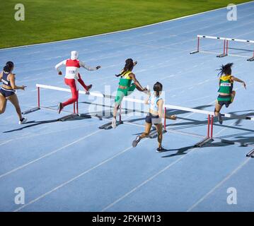 Atlete di pista e campo che saltano ostacoli in gara Foto Stock