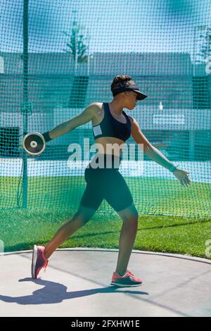 Pista femminile e atleta da campo che getta discus Foto Stock