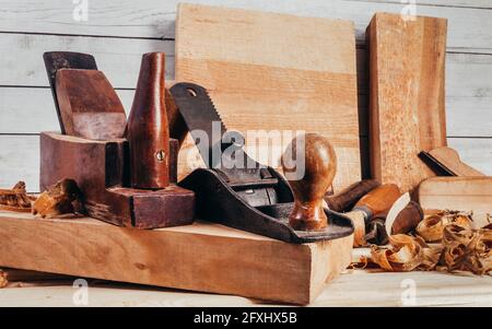 Foto di piani in legno vecchio stile con posa su banco da lavoro con segatura. Foto Stock