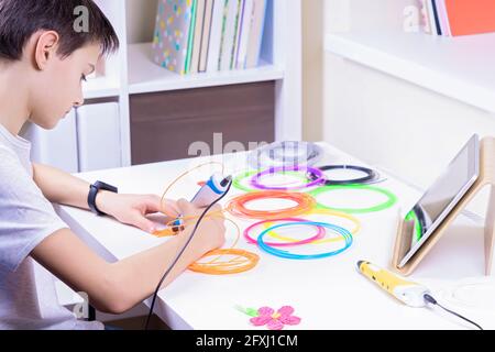 Figlio creazione di un nuovo oggetto 3D con penna 3d. Apprendimento, tecnologia, istruzione STEM, tempo libero, intrattenimento creativo a casa Foto Stock