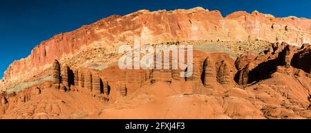 Colonne di sabbia e argilla sotto le ripide scogliere di WaterPocket Fold, Capitol Reef National Park, Utah, USA Foto Stock