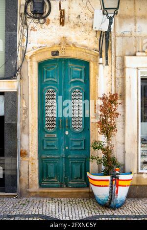 La porta in legno turchese sul lungomare di Olhao, Algarve, Portogallo Foto Stock