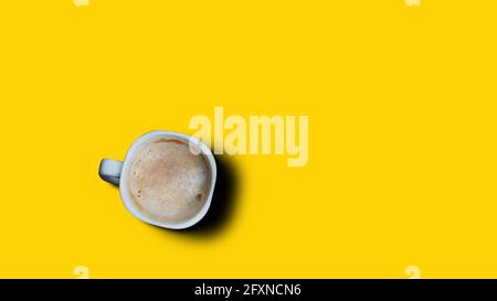 Vista dall'alto, disposizione piatta della tazza da caffè nera su sfondo giallo. Foto Stock