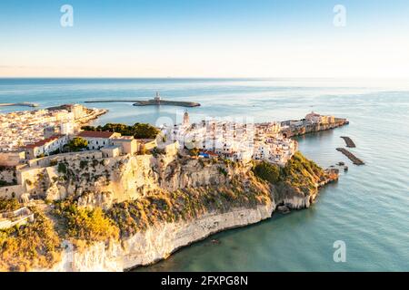 Centro storico di Vieste arroccato sulle scogliere all'alba, vista aerea, provincia di Foggia, Parco Nazionale del Gargano, Puglia, Italia, Europa Foto Stock