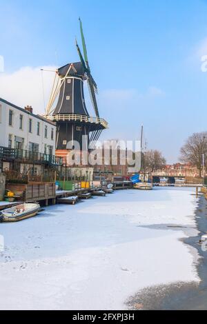 Windmill De Adriaan lungo il canale congelato del fiume Spaarne, Haarlem, quartiere di Amsterdam, Olanda del Nord, Paesi Bassi, Europa Foto Stock