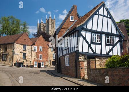 Vista su Michaelgate acciottolato alla Cattedrale di Lincoln, accovacciata casa a graticcio in primo piano, Lincoln, Lincolnshire, Inghilterra, Regno Unito, Europa Foto Stock