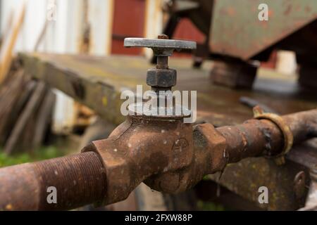 rubinetto dell'acqua e tubi dell'acqua arrugginiti, fonti di acqua per i campi degli agricoltori Foto Stock