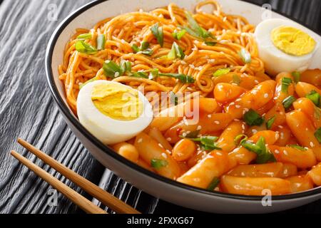 Il Rabokki coreano è quello che succede quando si mescola tteokbokki con gli spaghetti ramen closeup nella ciotola sul tavolo. Orizzontale Foto Stock