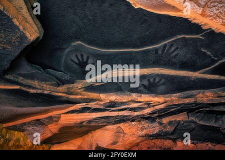 Antiche stampe a mano del pittogramma sul soffitto in arenaria sopra la rovina di Anasazi Fallen Roof nell'Altopiano Cedar Mesa dello Utah. Foto Stock