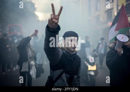 Un protestante circondato dal fumo fa un segno di pace protesta contro la Palestina libera, Kensington, Londra, 22 maggio 2021 Foto Stock