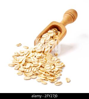 Scaglie di avena in cucchiaio di legno isolato su sfondo bianco. Un mucchio di avena per una confezione di farinata d'avena o di muesli Foto Stock