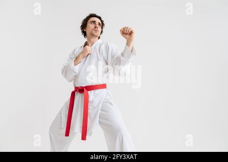 Uomo Karate che si esercita isolato su sfondo bianco Foto Stock