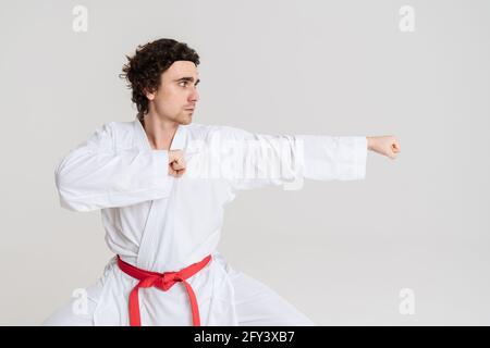 Uomo Karate che si esercita isolato su sfondo bianco Foto Stock