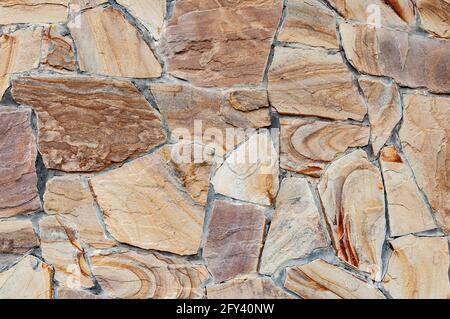 Arenaria arcobaleno. Roccia sedimentaria clastica composta principalmente da grani di silicato di dimensioni sabbiose. Muro di pietra. Sfondo. Primo piano. Foto Stock