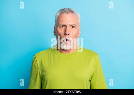 Foto di una persona anziano impressionata che apre la bocca fissando la camera cant credete isolati su sfondo di colore blu Foto Stock