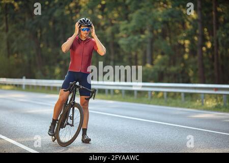 Ciclista che indossa casco per la protezione durante la guida Foto Stock