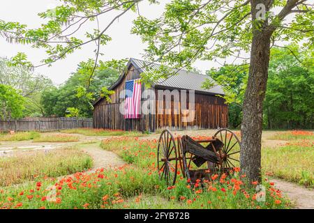 Castroville, Texas, Stati Uniti. 12 aprile 2021. Grande bandiera americana su un fienile nella regione collinare del Texas. Foto Stock