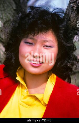 1980 RITRATTO SORRIDENTE GIOVANE DONNA COREANA CON BLUSA GIALLA ROSSA MAGLIONE GUARDANDO LA MACCHINA FOTOGRAFICA - KJ11209 TRA001 HARS SORRIDE COREANO GIOIOSA GIOVANE RAGAZZA ASIATICA-AMERICANA ADULTA VECCHIO STILE Foto Stock