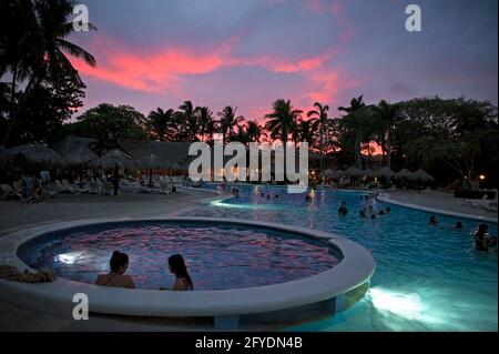 Persone che guardano il tramonto da una piscina in Costa Rica, America Centrale Foto Stock