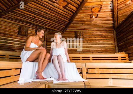 Senior e giovane donna in sauna sudare in calore Foto Stock