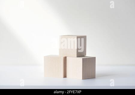 Tre blocchi quadrati di legno o cubetti sulla scrivania bianca. Mockup, spazio per il testo. Concetto di business picture Foto Stock