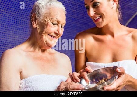 Donna al bagno Rasul nel centro benessere Foto Stock