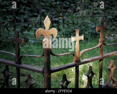 Fleur-de-lys emblema e un crocifisso in ferro battuto su una tomba, Welwyn, Inghilterra. Foto Stock