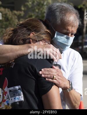 San Jose, Stati Uniti. 28 maggio 2021. La gente si abbracca ad una veglia commemorativa per nove lavoratori di transito uccisi a San Jose, California il giovedì 27 maggio 2021. Un collega ha sparato e ucciso nove dipendenti prima di uccidersi nel cantiere della ferrovia leggera VTA maggio 26. Photo by Terry Schmitt/UPI Credit: UPI/Alamy Live News Foto Stock