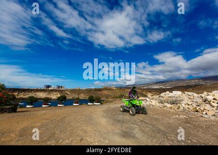 Un ragazzo in occhiali da sole sta cavalcando un ATV sopra la spiaggia Foto Stock