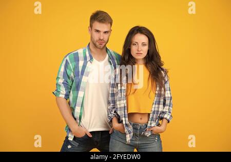 Il loro stile è molto più informale. Si accoppia in un abbigliamento casual. Vogue modelli sfondo giallo. Abiti di moda. Streetwear contemporaneo. Stile di vita alla moda Foto Stock