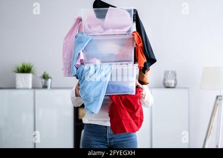 Donna decluttering e facendo lavanderia a casa Foto Stock